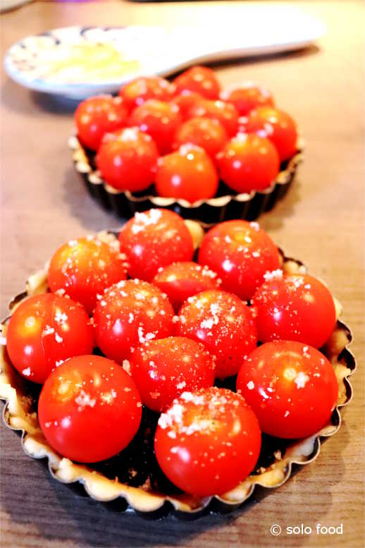 Tarts with cherry tomatoes and tapenade with black olives - ready for the oven